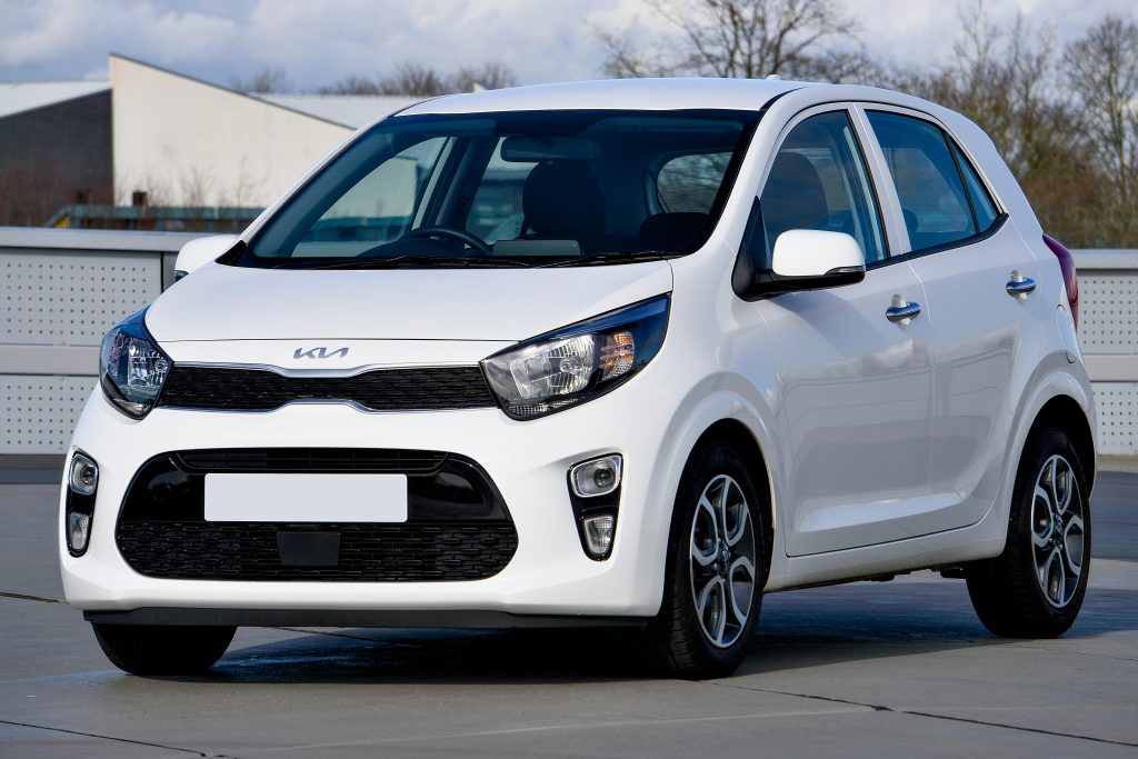A pristine white Kia Picanto parked in an urban setting in Harlow, United Kingdom.