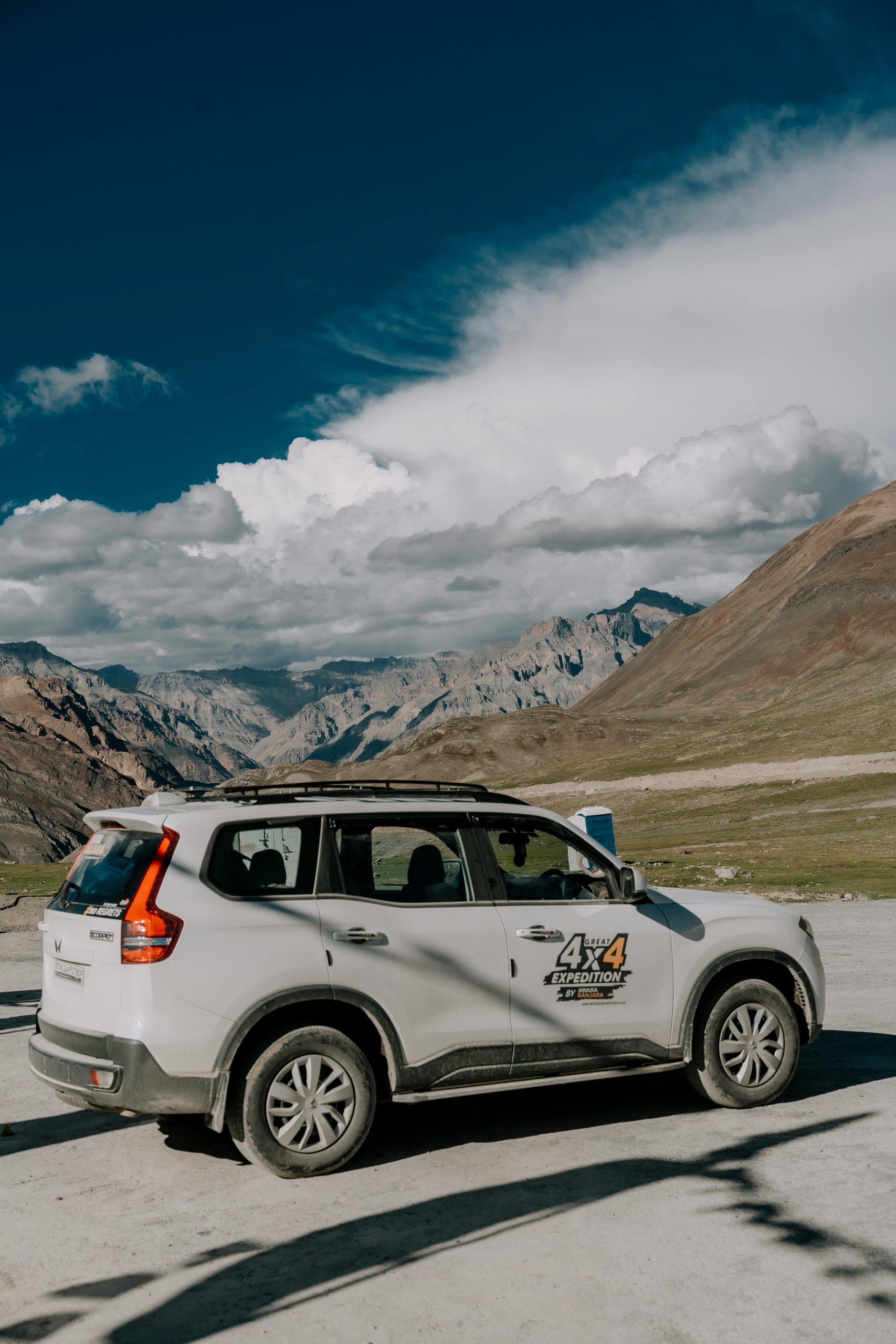 4x4 SUV parked in stunning mountain landscape under clear sky, showcasing outdoor adventure.