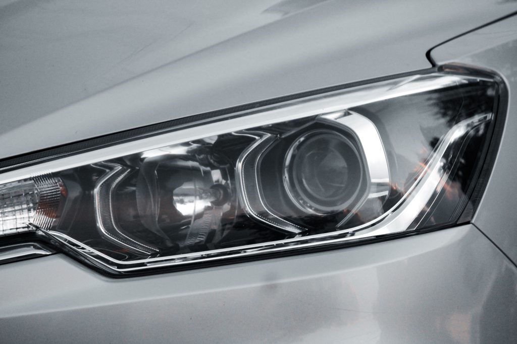 Detailed close-up of an elegant car headlight on a sleek vehicle.